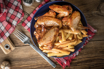 Baked chicken wings with french fries.