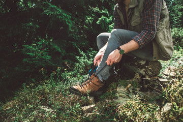 Take a break in journey and adventure. Close up side on portrait of young man sitting on stone of...