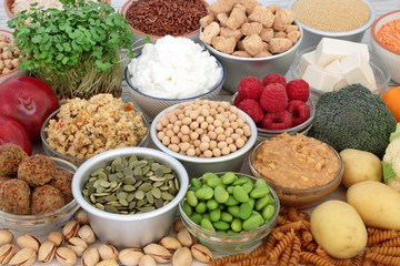 Vegan health food assortment with tofu bean curd, legumes, nuts, seeds, pasta, vegetables, sos mix, fruit, almond butter and yoghurt. High in antioxidants, dietary fibre, omega 3 and vitamins.