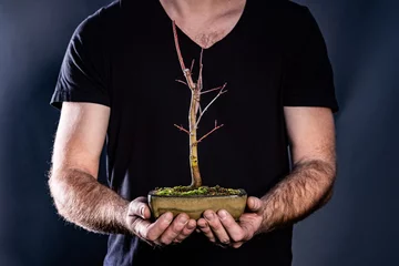 Crédence de cuisine en verre imprimé Bonsaï Homme tenant un bonsaï japonais