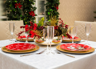 Christmas table setting for celebration at home. Glasses and stylish decoration for festive family...