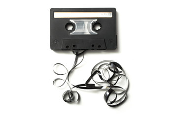 closeup of vintage audio cassette with magnetic band outside on white background