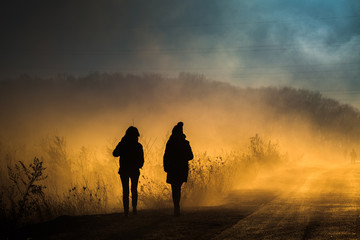 Morning walk in rural area filled with orange smoke