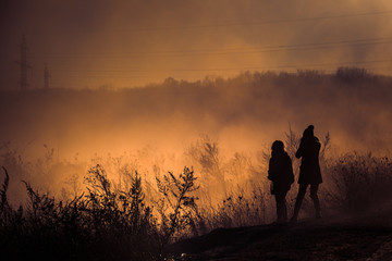 Obraz na płótnie Canvas Morning walk in rural area filled with orange smoke