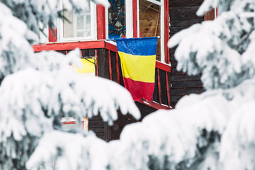 Romanian flag on winter mountain cabin