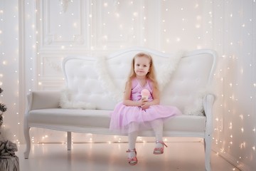 Lovely girl in purple dress in the background of Christmas decorations.