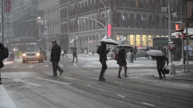 People crowd walking on city street during winter snow storm