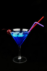 a beautiful glass with a refreshing drink of blue color with ice