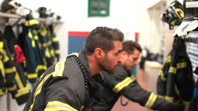 Two firefighters prepare for the uniform to work.