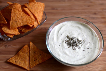 Bowl of broccoli, cheese and yoghurt dip and tortilla chips. Selective focus. 