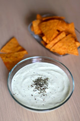 Bowl of broccoli, cheese and yoghurt dip and tortilla chips. Selective focus. 