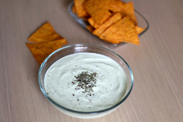 Bowl of broccoli, cheese and yoghurt dip and tortilla chips. Selective focus. 