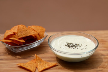 Bowl of broccoli, cheese and yoghurt dip and tortilla chips. Selective focus. 