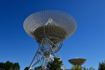 Array of satellite dishes or radio antennas against sky. Space o