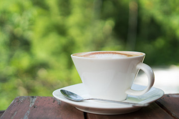 hot coffee in mug on wood table and natural background