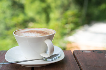 hot coffee in mug on wood table and natural background