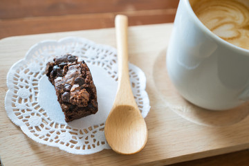 Chocolate brownie and Hot latte art coffee  on wood table