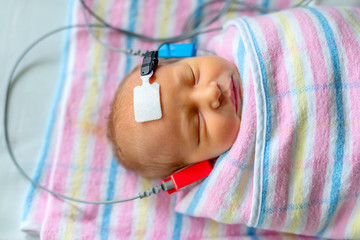 hearing test of a sleeping newborn at hospital