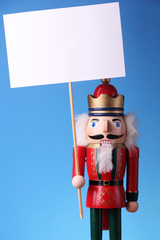Nutcracker doll holding a blank placard