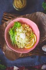 Cauliflower vegan vegetarian rice salad with fresh salad leaves in  bowl with spinach avocado sauce on red Christmas tablecloth. Healthy lunch or dinner