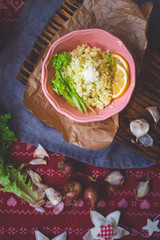 Cauliflower vegan vegetarian rice salad with fresh salad leaves in  bowl with spinach avocado sauce on red Christmas tablecloth. Healthy lunch or dinner