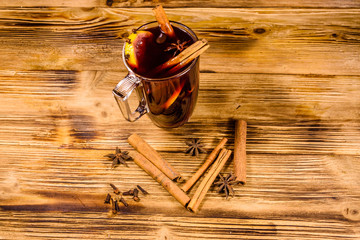 Cup of mulled wine with cinnamon on wooden table