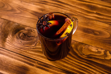 Cup of mulled wine with cinnamon on wooden table