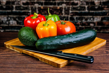 Slicing and chopping colorful Vegetables on a bamboo cutting board with a chef's knife.
