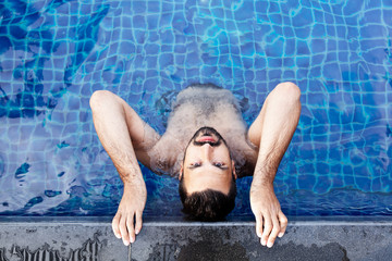 Handsome man in outdoor pool - obrazy, fototapety, plakaty