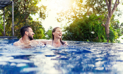 young beautiful couple man and woman have fun in the outdoor pool, squabbles, vacation and holiday,...