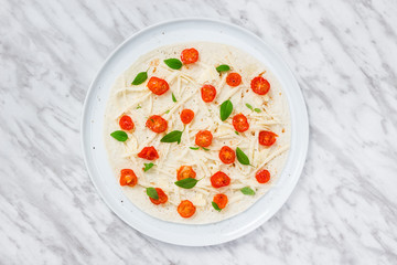 Preparing a tortilla with tomatoes, cheese and basil