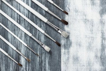 Paintbrushes on artistic background with gray brush strokes