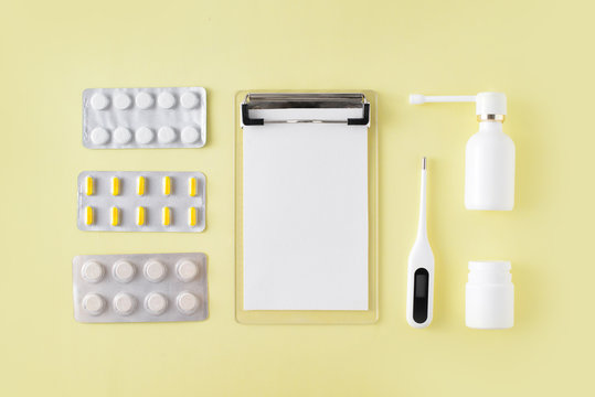 Pills, Thermometer And Note For Recipe On Yellow Background. Cold And Flu Treatment Set. Flat Lay, Top View.