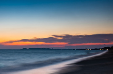 Obraz premium soft wave at sea beach on blue sky and orange cloud sun set, long exposure shot