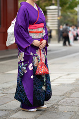 Young girl wearing Japanese kimono standing in front of Sensoji Temple in Tokyo, Japan. Kimono is a Japanese traditional garment. The word "kimono", which actually means a "thing to wear"