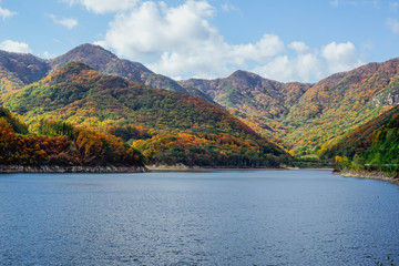 Beautiful mountain lake in the valley of the hills, in autumn, among thousands of colorful trees. Iwon Village, South Korea