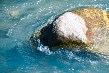 Sea water crashing on a stone.