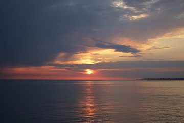 Obraz premium Amazing sunset on the ocean. View of dramatic cloudy sky and reflection of the sunlight on water.