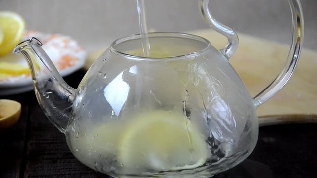 put turmeric honey hot water in a teapot to make a healthy drink. Teapot of ginger tea with honey and lemon on wooden table. Cup of ginger tea with honey and lemon on wooden table