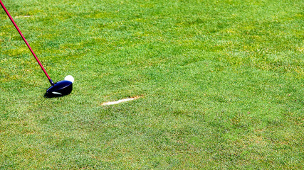 chipping a golf ball onto the green with golf club