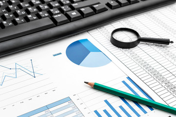 Obraz premium Black computer keyboard with pencil on documents with financial data.