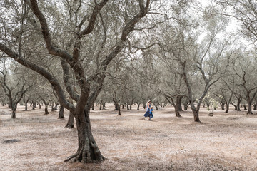 Mom and son running in olive grove