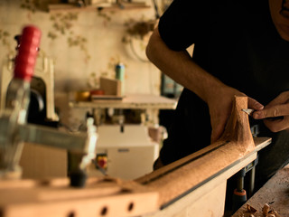 The guitar master makes a guitar neck.