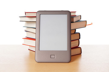modern ebook reader stacked against pile of old books                              