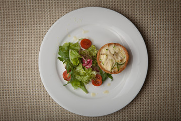 julienne in tartlet with salad and tomatoes on a white plate