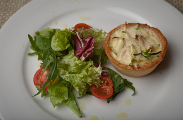 julienne in tartlet with salad and tomatoes on a white plate