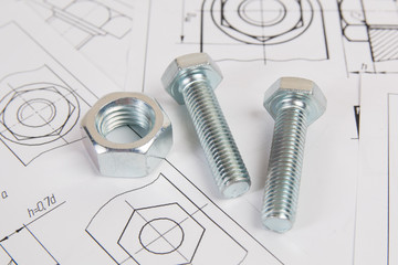 Technical drawings of bolt and nut. Engineering, technology and metalworking. Metal bolt and nut on printed drawings background. - obrazy, fototapety, plakaty