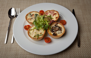 julienne in tartlet with salad and tomatoes on a white plate