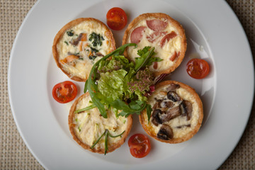 julienne in tartlet with salad and tomatoes on a white plate