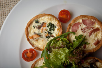 julienne in tartlet with salad and tomatoes on a white plate
